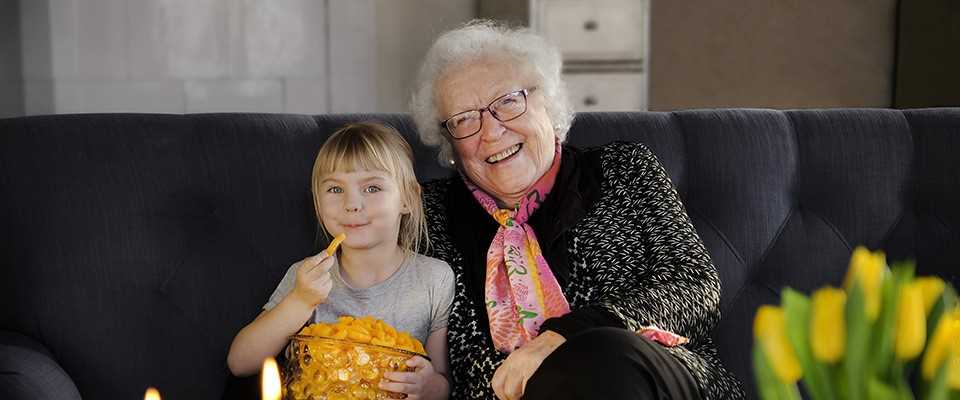 Kvinna och barnbarn tittar på TV